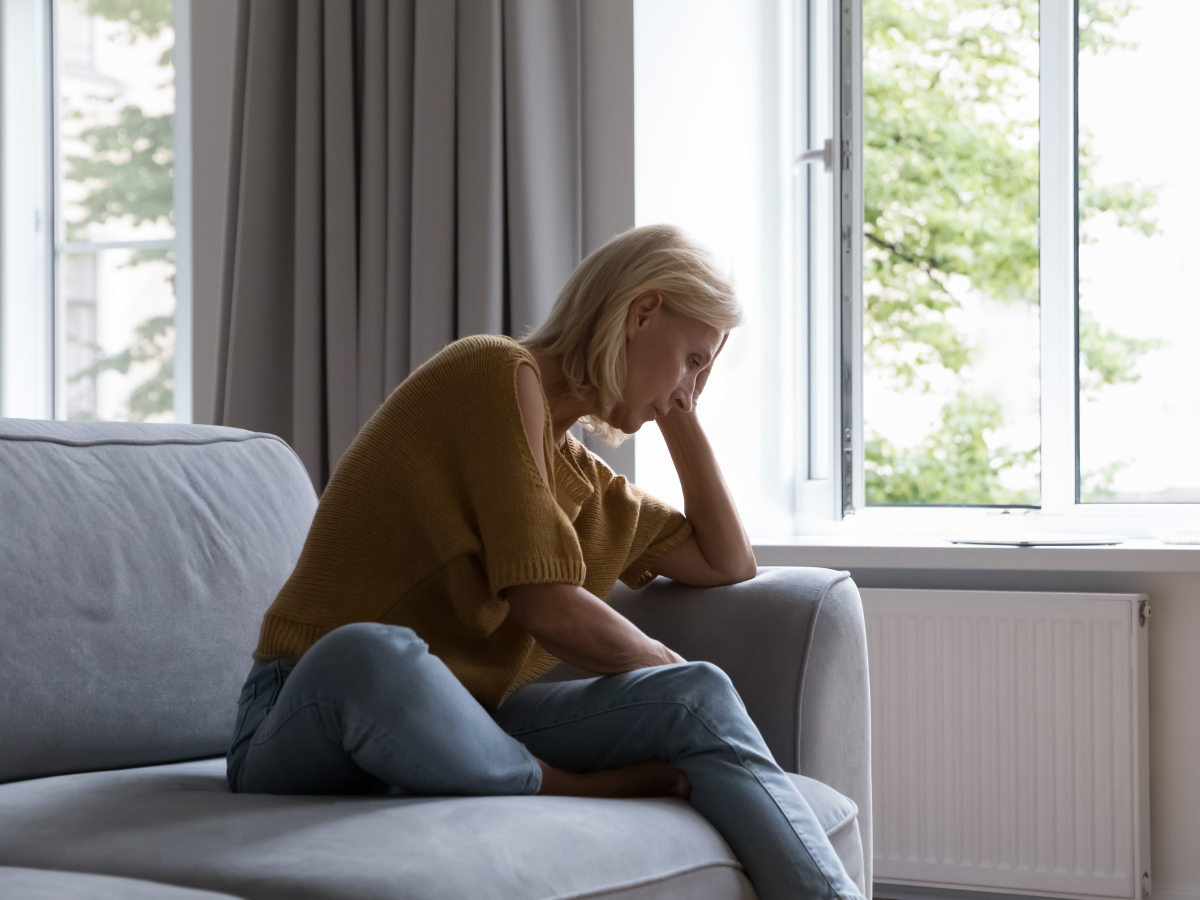 passive-active-suicidal-ideation-difference woman on couch thinking about getting a mental health assessment for her passive or active suicidal thoughts